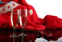 Two glasses of champagne, a ribbon and a red Santa Claus costume