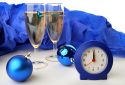 Two glasses of champagne with a clock and Christmas balls for the new year