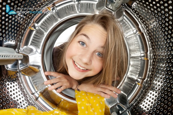 Portrait jeune enfant regardant à l'intérieur d'une machine à laver le linge