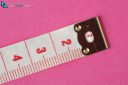 Tape measure close-up isolated on pink background showing four centimeter