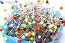 Blue box of multicolored sewing pins on a white background