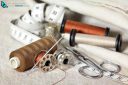 Set of sewing accessories: spools of brown thread, sepia and a needle, a pair of scissors and a tape measure