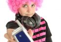 Young girl with pink hair shows a vintage telephone