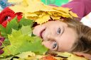 Close-up of a pretty girl lying in a pile of multicolored autumn leaves