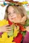 girl playing with a bunch of autumn leaves