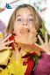 girl looking at camera and playing with a bunch of autumn leaves