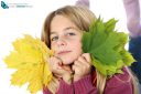 girl holding autumn leaves on white background