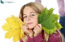 girl holding autumn leaves on white background