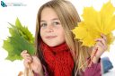 Young girl portrait with autumn leaves in studio