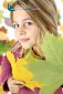 Autumn child portrait with leaves close-up.