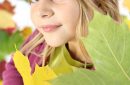 Autumn child portrait with leaves close-up.