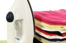 A steam iron on an ironing board and white background