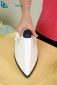 A woman's hand picks up a steam iron from an ironing board