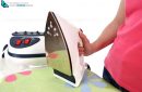 A steam iron on an ironing board and white background