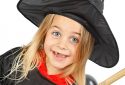 Halloween portrait of a child in a witch costume and broom
