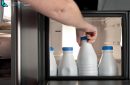 Man hand taking a bottle of milk from a fridge