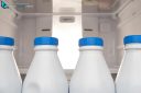 Four bottle milk aligned in the fridge door