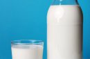 Full milk bottle with glass  for breakfast isolated on blue background