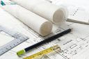 Work tool equipment laid out on house and kitchen construction plans with rolls of architect drawings