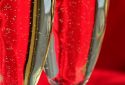 Close up of two glasses of champagne on red background
