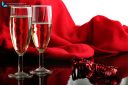 Close up of two glasses of champagne on red background with ribbon