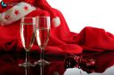 Two glasses of champagne, a ribbon and a red Santa Claus costume