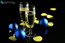 Two champagne glasses, blue Christmas balls and confetti on a black background