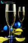 Close up of two champagne glasses, blue Christmas balls and confetti on black background