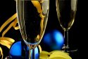 Close up of two champagne glasses, ribbon and confetti on black background