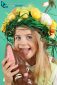 Young girl with Easter eggs on her head eats a chocolate bunny