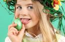 Young girl wearing fun hairstyle on Easter day eats chocolate eggs