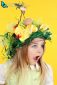 Portrait of child with chocolate eggs on yellow background for Easter