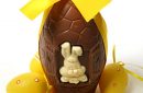 Big chocolate Easter egg with yellow ribbon, Easter bunny and decorative eggs, isolated on white background