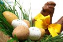 Traditional basket of Easter eggs on fresh grass with a chocolate hen
