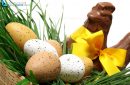 Traditional basket of Easter eggs on fresh grass with a chocolate hen