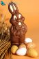 chocolate Easter rabbit with eggs on orange background
