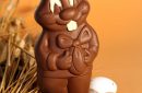 chocolate Easter rabbit with eggs on orange background