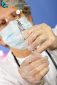 The nurse or head doctor wearing protective gloves and a mask prepares a large needle for vaccine injection or medical treatment. Hands and syringe close-up